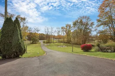 an empty road in a park with trees and bushes at The Nook on the Farm with Pool,Hot tub and Games in Pataskala
