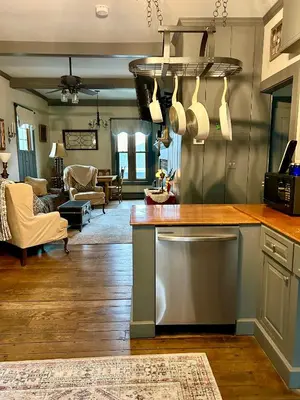 a kitchen with a counter top and a living room at Historic King House Above The Keep Tavern
