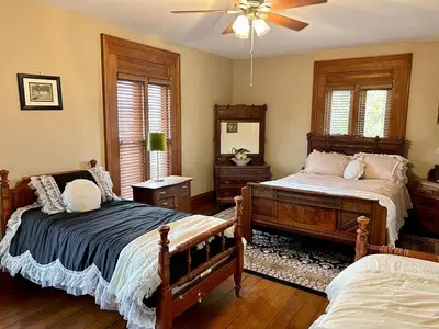 a bedroom with two beds and a ceiling fan at Historic King House Above The Keep Tavern