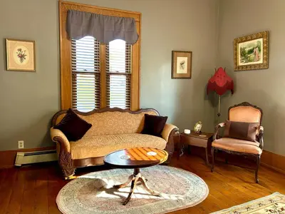 a living room with a couch and a chair at Historic King House Above The Keep Tavern
