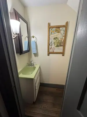 a bathroom with a sink and a mirror at Historic King House Above The Keep Tavern