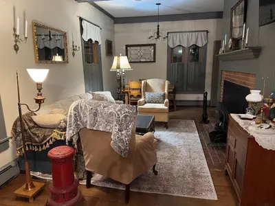 a living room with a couch and a fireplace at Historic King House Above The Keep Tavern