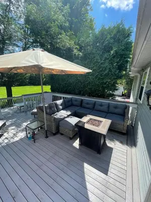 a patio with a couch and an umbrella at Quiet Guest Space with Hot Tub, Laundry, and Gym in Chagrin Falls