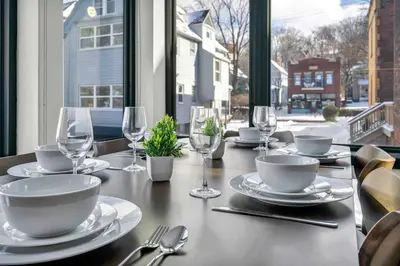 a table with plates and wine glasses on a table at CWRU & Little Italy Stay with King Bed Gym Parking WD in Cleveland