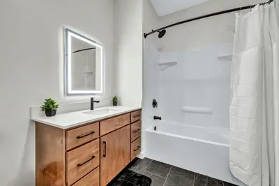 a bathroom with a sink and a tub and a shower at CWRU & Little Italy Stay with King Bed Gym Parking WD in Cleveland