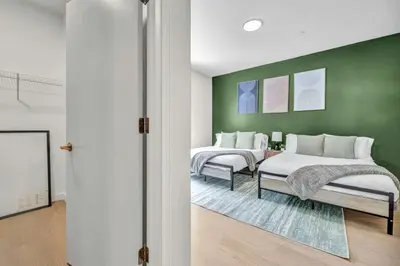 two beds in a room with a green wall at CWRU & Little Italy Stay with King Bed Gym Parking WD in Cleveland
