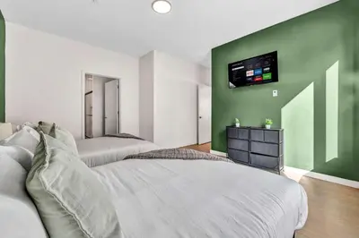 a bedroom with two beds and a tv on the wall at CWRU & Little Italy Stay with King Bed Gym Parking WD in Cleveland