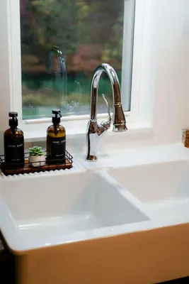 a sink with two bottles of soap next to a window at The 312 House| A Boho Retreat| Hocking Hills in Logan