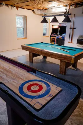 a ping pong table in a room with a pool at The 312 House| A Boho Retreat| Hocking Hills in Logan