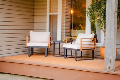 two chairs and a table on a porch at The 312 House| A Boho Retreat| Hocking Hills in Logan