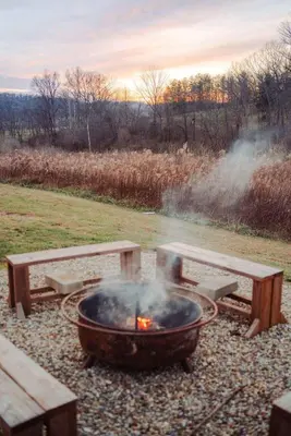 a fire pit with two benches and a picnic table at Cedar Wrapped Cozy Villa Cabin - 4 miles from Trails in Laurelville