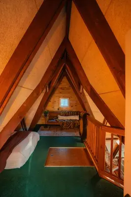 an attic room with a roof with a bed at Waterfront A- Frame with Dock, Canoe + Kayaks in Rockbridge