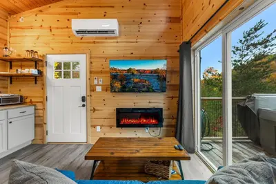 a living room with a fireplace in a tiny house at The Dragonfly - Tiny Mountaintop Cabin with Hot tub in Stanton