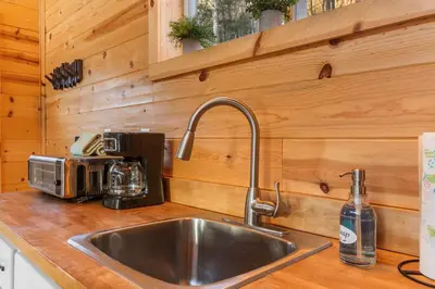 a kitchen counter with a sink in a wooden kitchen at The Hummingbird - Mountaintop Cabin with Hot Tub in Stanton