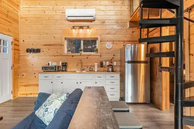 a kitchen with a bench in the middle of a room at The Hummingbird - Mountaintop Cabin with Hot Tub in Stanton