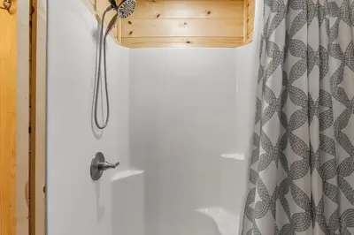 a shower with a white door with a shower curtain at The Hummingbird - Mountaintop Cabin with Hot Tub in Stanton