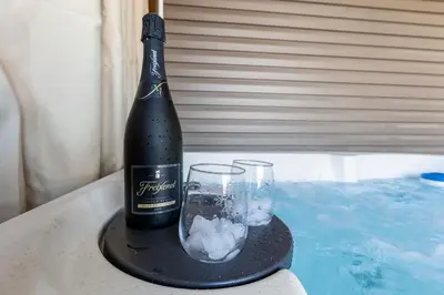 a bottle of champagne and a glass on a table at 2 Hot Tubs/Private Bar/ Pickleball & Basketball Ct in Georgetown