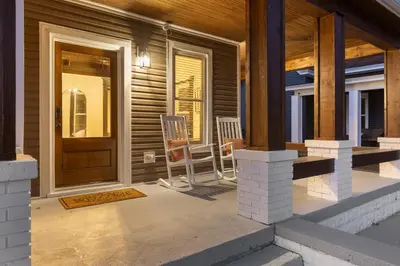 a porch with two chairs and a wooden door at 2 Hot Tubs/Private Bar/ Pickleball & Basketball Ct in Georgetown