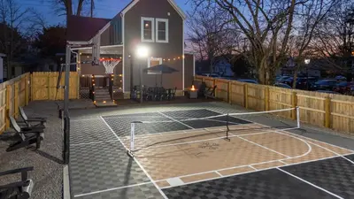 a tennis court with a net in front of a house at 2 Hot Tubs/Private Bar/ Pickleball & Basketball Ct in Georgetown