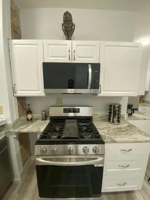 a kitchen with a stove and a microwave at Brand new home just minutes from downtown Cincinnati in Cincinnati