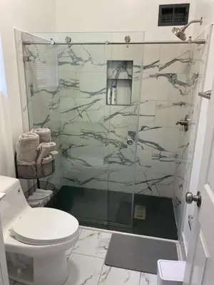 a bathroom with a glass shower with a toilet at Brand new home just minutes from downtown Cincinnati in Cincinnati