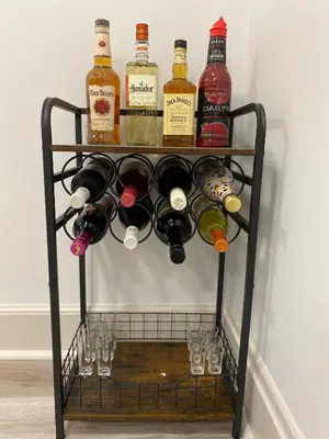 a wine rack with wine bottles and glasses on it at Brand new home just minutes from downtown Cincinnati in Cincinnati