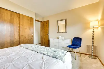 a bedroom with a bed and a blue chair at Great for Travel Nurses! Home 4 Mi to Dtwn Troy in Troy