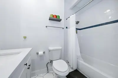 a white bathroom with a toilet and a sink and a tub at Mt Adams Lookout with Best City View and Parking in Cincinnati