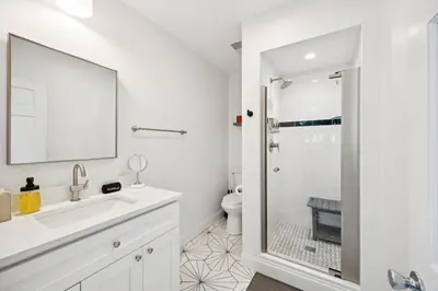 a white bathroom with a sink and a shower at Mt Adams Lookout with Best City View and Parking in Cincinnati