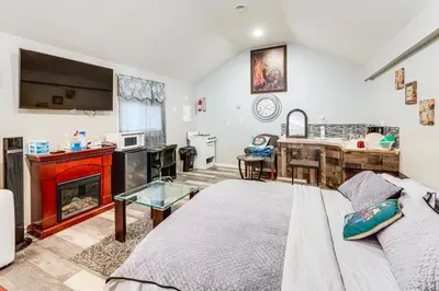 a living room with a bed and a kitchen at 8 Mi to Dtwn CLE Cozy Couples Retreat with Gym! in Cleveland