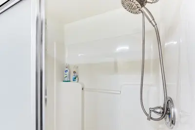 a shower with a shower head in a bathroom at 8 Mi to Dtwn CLE Cozy Couples Retreat with Gym! in Cleveland