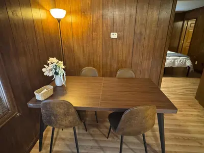 a wooden table with chairs and a vase of flowers at Prime 1BR- Minutes to Toledo, Sylvania and MI in Toledo