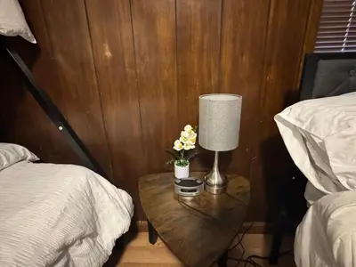 a bedroom with a table with a lamp and flowers at Prime 1BR- Minutes to Toledo, Sylvania and MI in Toledo