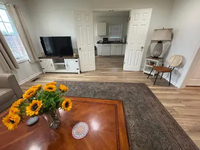 a living room with a vase of sunflowers on a table at Spacious 2BR Apartment near Toledo, Sylvania & MI in Toledo