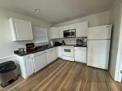 a kitchen with white cabinets and a refrigerator at Spacious 2BR Apartment near Toledo, Sylvania & MI in Toledo