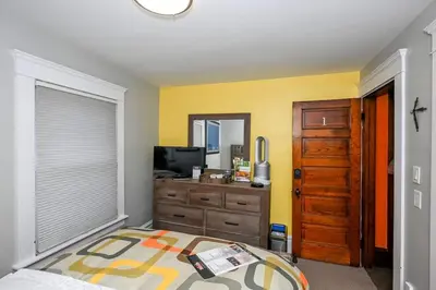 a bedroom with a bed and a dresser and a television at Cozy Berrodin Bed And Breakfast Whole House Booking In Highland Square Akron in Akron
