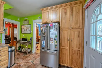 a kitchen with a stainless steel refrigerator and wooden cabinets at Cozy Berrodin Bed And Breakfast Whole House Booking In Highland Square Akron in Akron