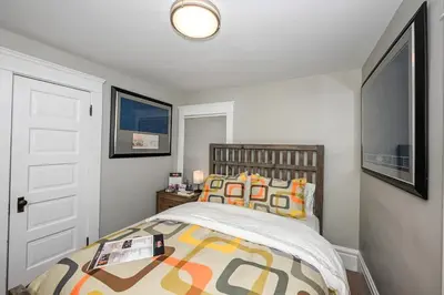 a bedroom with a bed with colorful pillows at Cozy Berrodin Bed And Breakfast Whole House Booking In Highland Square Akron in Akron