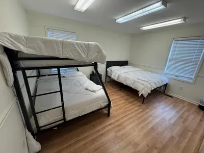 two bunk beds in a room with wooden floors at Modern 2BR Suite 202- Toledo & Sylvania Gateway in Toledo