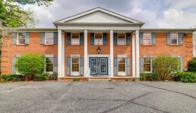 a large brick house with a blue door at Modern 2BR Suite 202- Toledo & Sylvania Gateway in Toledo