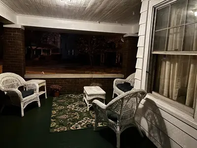a porch with wicker chairs and a table on a house at The Inn on Holgate Avenue in Defiance