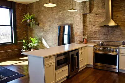 a kitchen with a counter and a brick wall at The Historic Berry Loft at Waterfront Hall in Wheeling