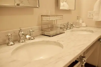 a bathroom with two sinks and a marble counter top at The Historic Berry Loft at Waterfront Hall in Wheeling