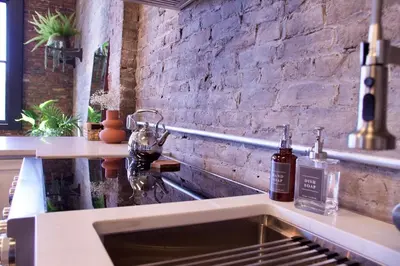 a kitchen with two bottles of alcohol on a counter at The Historic Berry Loft at Waterfront Hall in Wheeling