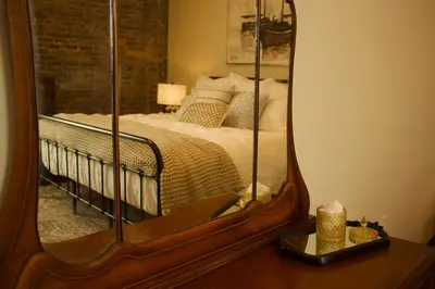 a bedroom with a bed with a mirror on a table at The Historic Berry Loft at Waterfront Hall in Wheeling