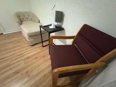 a living room with a chair and a table with a lamp at Sunset Cornfield Oasis in Whiteford Center