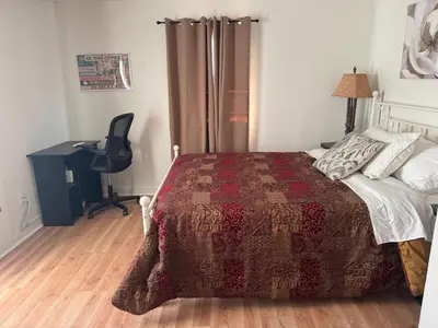 a bedroom with a bed and a desk and a chair at Sunset Cornfield Oasis in Whiteford Center