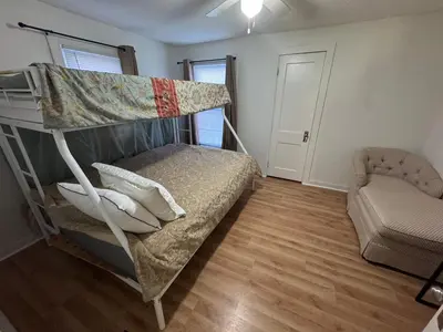 a bedroom with a bunk bed and a chair at Sunset Cornfield Oasis in Whiteford Center