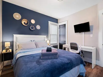 a bedroom with a bed and a desk and a tv at Stylish Lakeside Living - walk to the beach in Cleveland