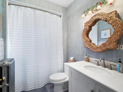 a bathroom with a white toilet and a mirror at Stylish Lakeside Living - walk to the beach in Cleveland